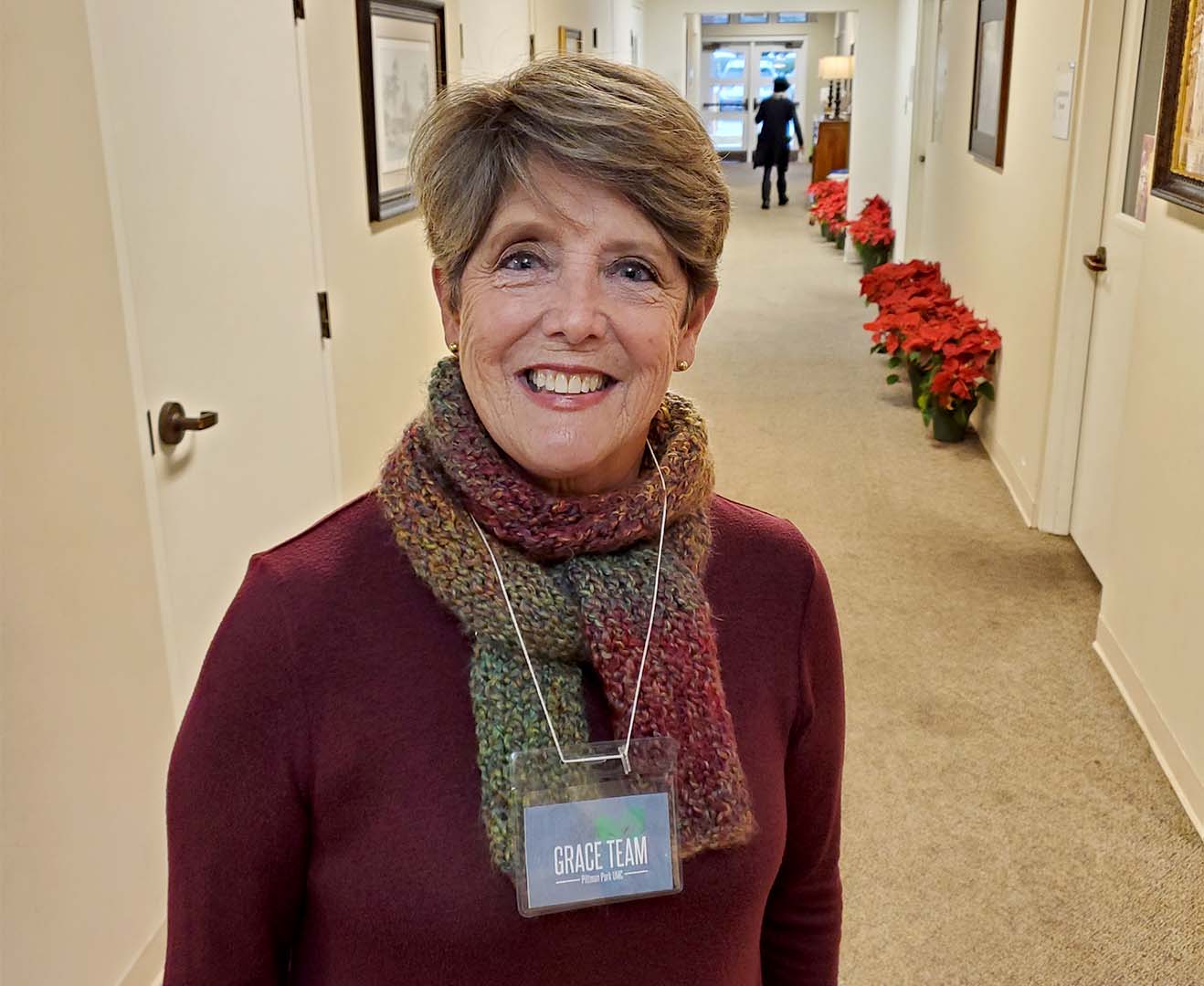 Smiling woman wearing Grace Team badge