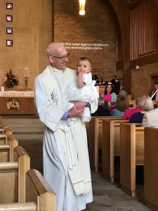 Pastor Bill holding Ellie Wright, age 1, after her baptism