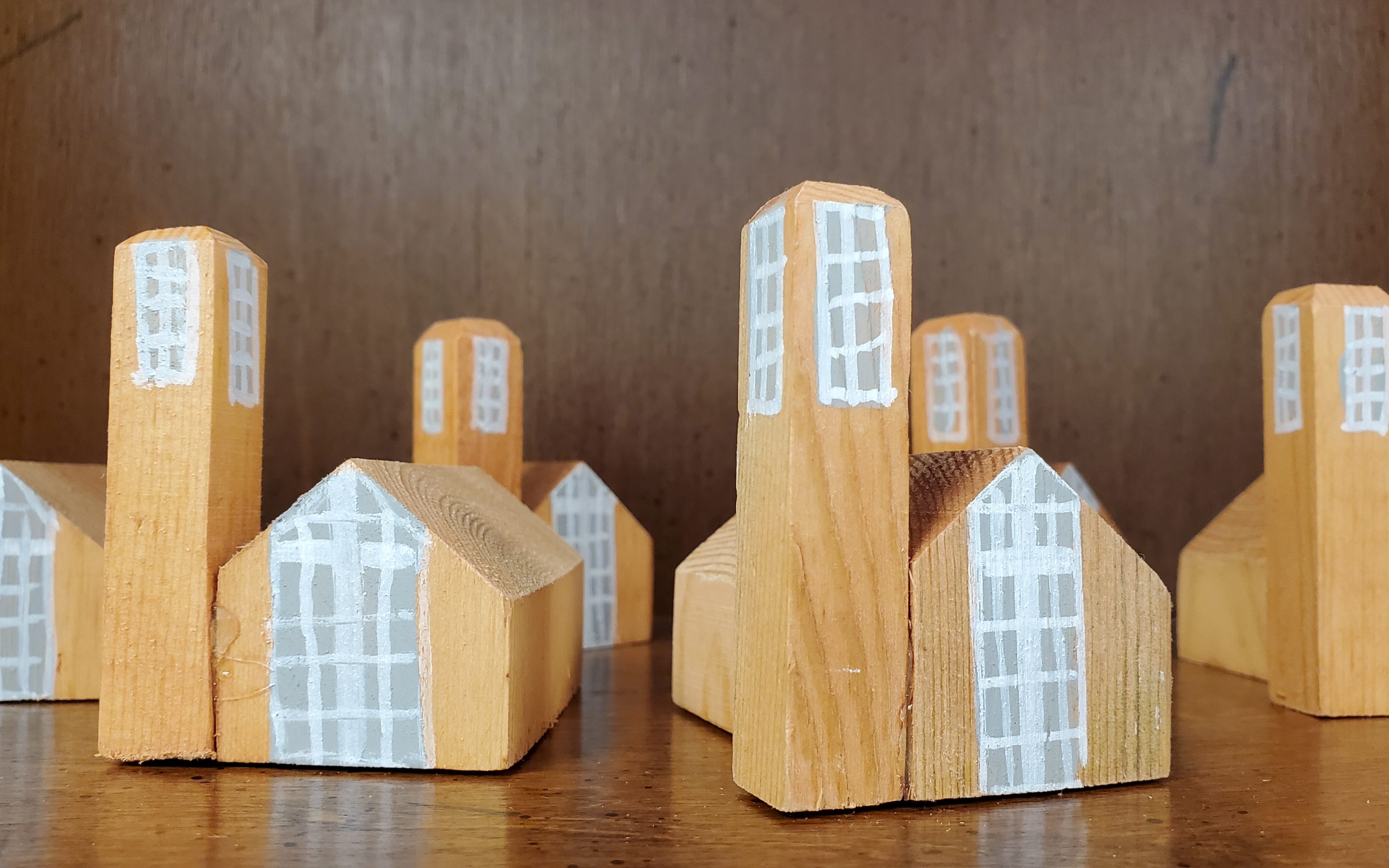 a close-up photo of several small, wooden blocks that have the shape and painted windows to look like Pittman Park Church