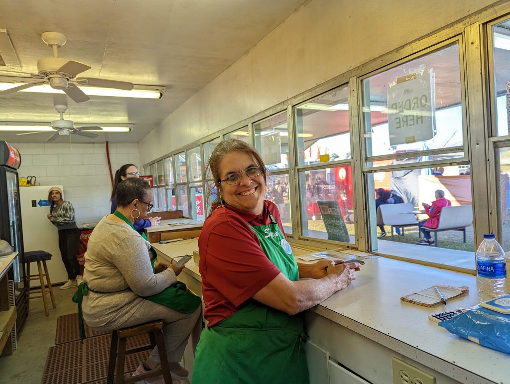 Photo of Lisa Dunn at the counter of the Fair Food Booth