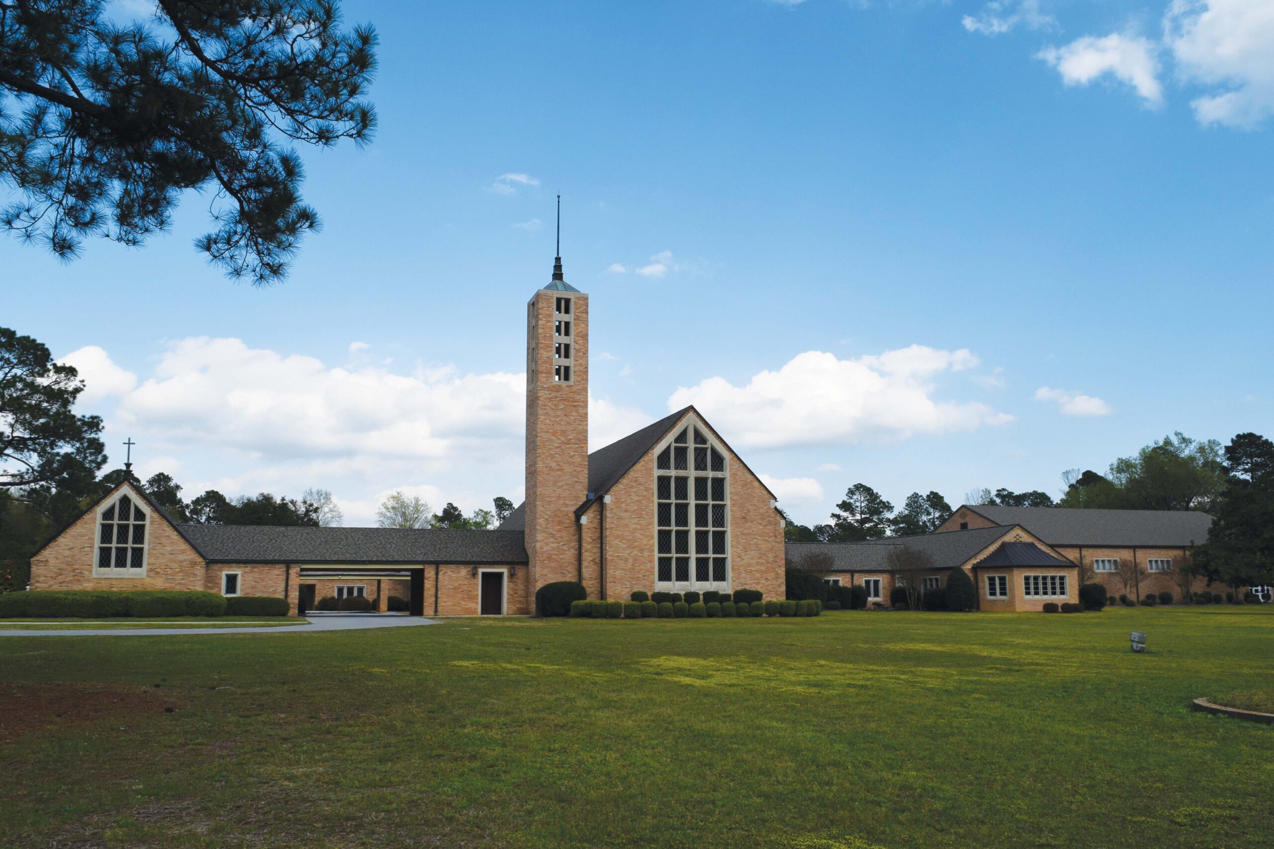 Stone building with tall belltower and pointed roof